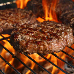 Hamburger patty being grilled on an open flame